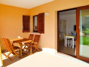 un comedor con mesa y sillas en una habitación en Apartment I Mirti di Porto Pozzo - PPZ120 by Interhome, en Porto Pozzo