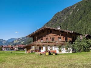 ciągnik zaparkowany przed domem na polu w obiekcie Apartment Gredler-2 by Interhome w Mayrhofen