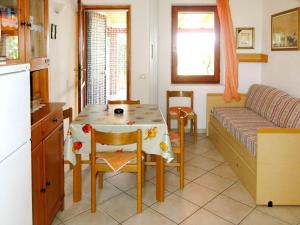 a kitchen and dining room with a table and a couch at Holiday Home Rei Mare Fronte Marina - REI205 by Interhome in Monte Nai