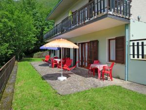 un patio con mesas, sillas y una sombrilla en Holiday Home Villa Martinelli-3 by Interhome, en Vesta