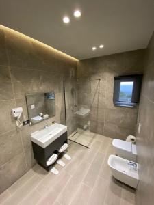 a bathroom with a sink and a shower and a toilet at Ardenica Boutique Hotel in Lushnjë +110 photos