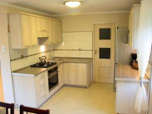 a kitchen with white cabinets and a stove top oven at Holiday Home Mazurska Sielanka by Interhome in Trygort