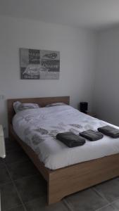 a bed with white sheets and black pillows on it at Magnifique maison avec baignoire balnéo in Cornebarrieu