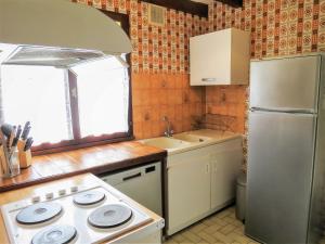 a small kitchen with a stove and a refrigerator at Holiday Home Vignas by Interhome in Le Porge
