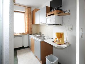 mała kuchnia ze zlewem i kuchenką mikrofalową w obiekcie Apartment Falkner-1 by Interhome w mieście Oberlängenfeld