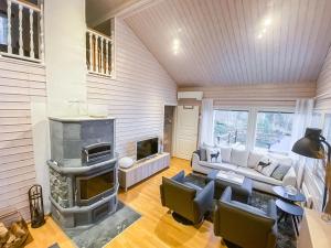 ein Wohnzimmer mit einem Sofa und einem Kamin in der Unterkunft Holiday Home Villa sipilä by Interhome in Savonranta