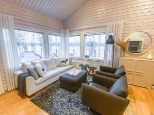 ein Wohnzimmer mit einem weißen Sofa und 2 Stühlen in der Unterkunft Holiday Home Villa sipilä by Interhome in Savonranta