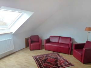 a living room with two red chairs and a rug at Holiday Home Adda by Interhome in Neßmersiel