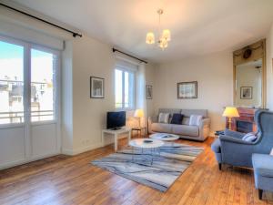 a living room with a couch and a table at Apartment L'Anse by Interhome in Dinard