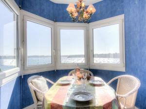 una sala da pranzo con tavolo e 4 finestre di Apartment Le Beauvoir Rose by Interhome a Dinard