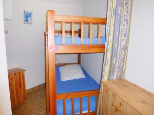 a wooden bunk bed with a blue mattress at Apartment Camargue Village-2 by Interhome in Le Grau-du-Roi