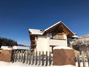 a house with a fence in the snow at Apartment Canada by Interhome in Sanzeno