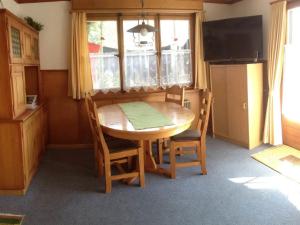 アデルボーデンにあるApartment Sunnegruess by Interhomeのキッチン(木製テーブル、椅子、テレビ付)
