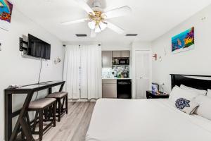 a bedroom with a bed and a desk and a kitchen at The Inn at St. Thomas Square #1203A in Panama City Beach