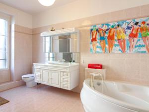 y baño con bañera, lavabo y aseo. en Apartment L'écluse-1 by Interhome, en Dinard