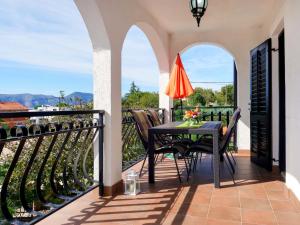 a patio with a table and chairs on a balcony at Apartment Dilly - KRK116 by Interhome in Pinezici