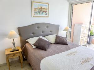 um quarto com uma cama com duas almofadas em Apartment Le Méditerranée-2 by Interhome em Fréjus