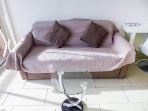 uma sala de estar com um sofá e uma mesa de vidro em Apartment Le Méditerranée-2 by Interhome em Fréjus