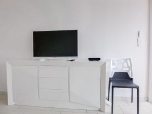 a white desk with a tv and a chair at Apartment Le Méditerranée-2 by Interhome in Fréjus +18 photos