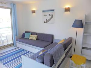 uma sala de estar com um sofá e uma janela em Apartment L'Open-6 by Interhome em Fréjus
