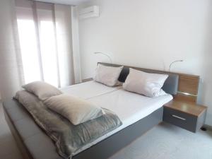a bed with white sheets and pillows next to a window at Apartment Brake by Interhome in Offenburg
