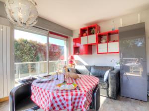 een woonkamer met een tafel met een rode en witte tafelkleed bij Apartment Le Parc de La Ronceray-1 by Interhome in Dinard