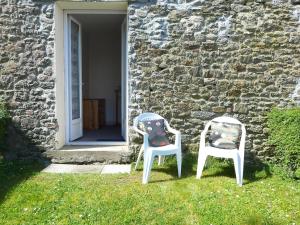 deux chaises assises dans l'herbe devant un bâtiment dans l'établissement Apartment Le Petit Robinson-1 by Interhome, à La Richardais