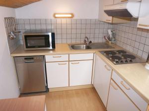małą kuchnię ze zlewem i kuchenką mikrofalową w obiekcie Apartment Quadratsch by Interhome w mieście Pians