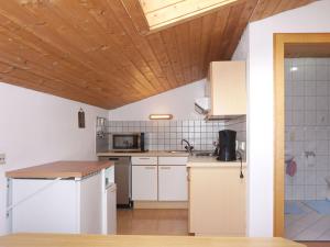 PiansにあるApartment Quadratsch by Interhomeの木製の天井、白い家電製品付きのキッチン
