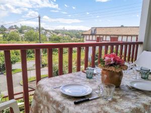 einen Tisch mit Tellern und Blumen auf dem Balkon in der Unterkunft Apartment Hego Alde by Interhome in Bidart