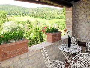 a patio with a table and chairs and a view at Apartment Le Sodole - Petunia by Interhome in San Gimignano