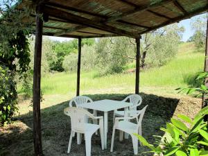 a white table and chairs under a pergola at Apartment Le Sodole - Petunia by Interhome in San Gimignano