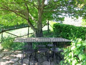 una mesa y sillas bajo un árbol en un jardín en Studio General Massena - NAZ109 by Interhome, en Bene Vagienna