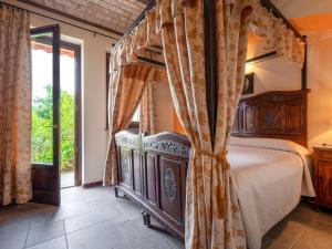 1 dormitorio con cama con dosel y ventana en Holiday Home General Massena - NAZ110 by Interhome, en Bene Vagienna