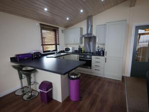 a kitchen with a black counter top in a room at Chalet Loch Leven Lodge by Interhome in Ballingry