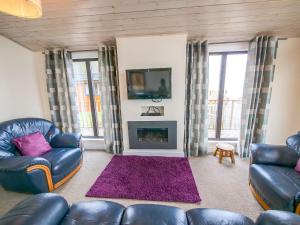a living room with two couches and a fireplace at Chalet Loch Leven Lodge by Interhome in Ballingry