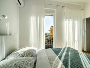 een witte slaapkamer met een bed en een raam bij Holiday Home Dario by Interhome in Novigrad Istria