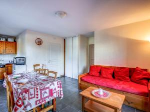 a living room with a red couch and a table at Apartment Les erables by Interhome in Saint-Gervais-les-Bains