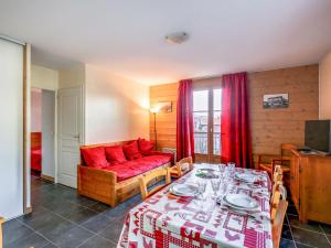 a living room with a red couch and a table at Apartment Les erables by Interhome in Saint-Gervais-les-Bains