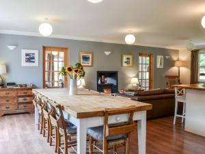 a kitchen and living room with a large wooden table and chairs at Holiday Home Feochan Bheag by Interhome in Kilmore