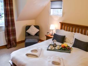 a bedroom with a bed with a tray of food on it at Holiday Home Feochan Bheag by Interhome in Kilmore