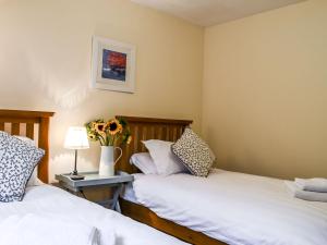 two beds sitting next to each other in a bedroom at Holiday Home Feochan Bheag by Interhome in Kilmore