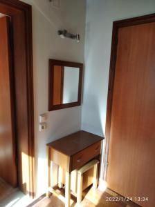ein Badezimmer mit einem Holztisch und einem Spiegel in der Unterkunft Stefanos in Megisti