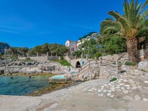 a beach with a bridge and a palm tree at Apartment Martina by Interhome in Selca kod Bogomolja