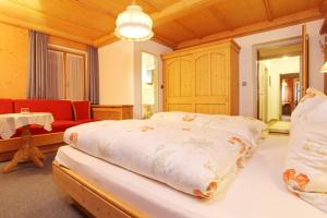 ein Schlafzimmer mit einem großen Bett und einer roten Couch in der Unterkunft Beim Rottmeister in Reit im Winkl
