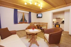 ein Wohnzimmer mit Tisch und Stühlen und eine Küche in der Unterkunft Beim Rottmeister in Reit im Winkl