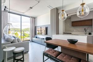 une cuisine et un salon avec une table et un canapé dans l'établissement WI-FI 300MB | Rooftop com Piscina em Jurerê #JA15, à Florianópolis