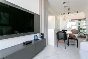 un salon avec une grande télévision à écran plat sur un mur dans l'établissement WI-FI 300MB | Rooftop com Piscina em Jurerê #JA15, à Florianópolis