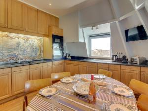 a kitchen with a table with plates and a bottle of wine at Apartment Château des Deux Rives by Interhome in Dinard