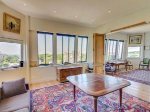 a living room with a table and some windows at Apartment Château des Deux Rives by Interhome in Dinard